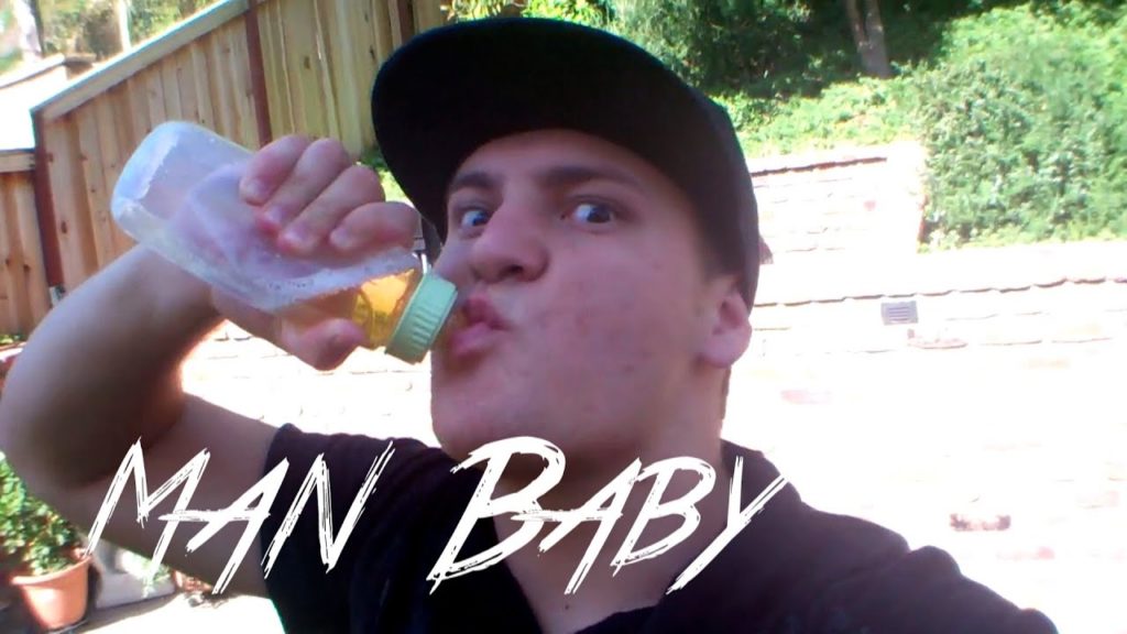young man drinking beer from a baby bottle